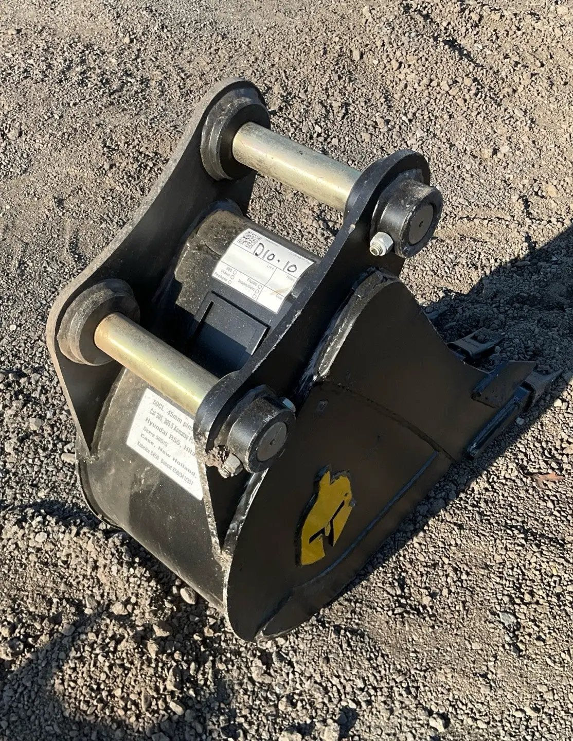 Trojan 12in excavator bucket attachment for 5-ton machines (CAT 305/JD50/PC55), black steel with mounting pins.