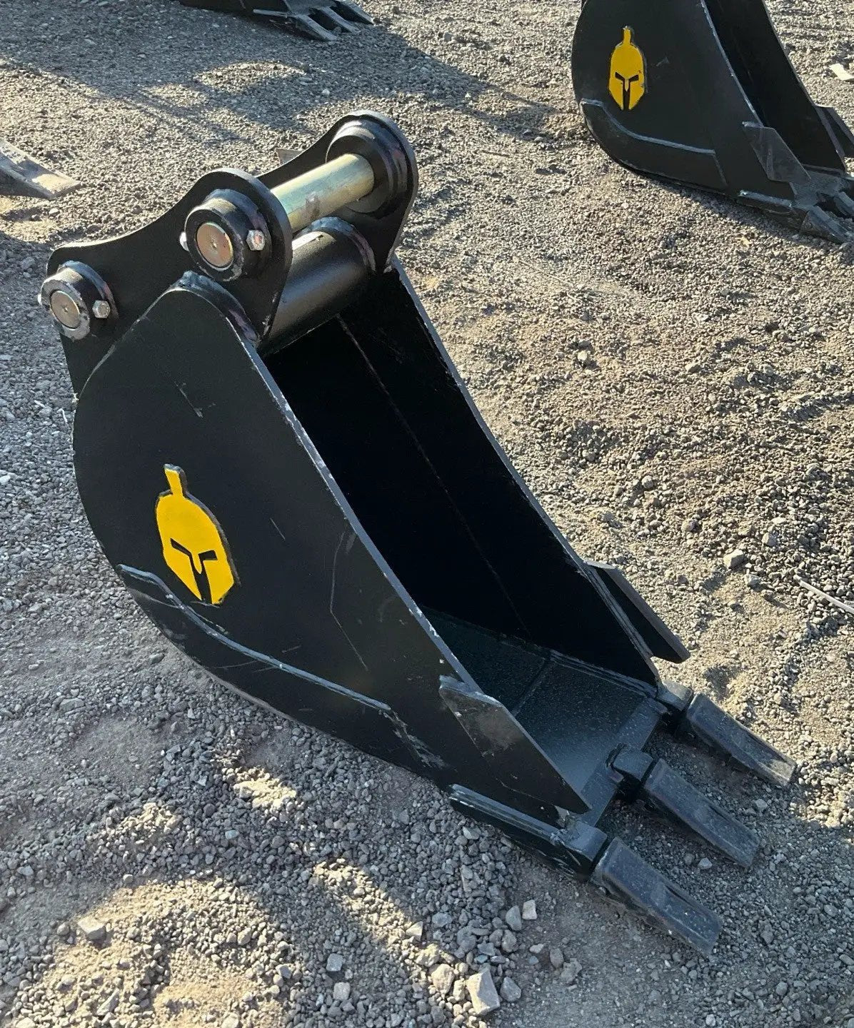 Trojan 12-inch excavator bucket attachment with black bucket and yellow Trojan logo.