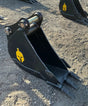 Trojan 12-inch excavator bucket attachment with black bucket and yellow Trojan logo.